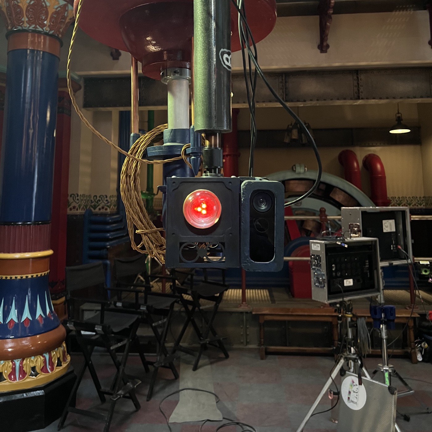 An Azure Kinect mounted in the set with its infrared emitter glowing red, cabling running away behind it