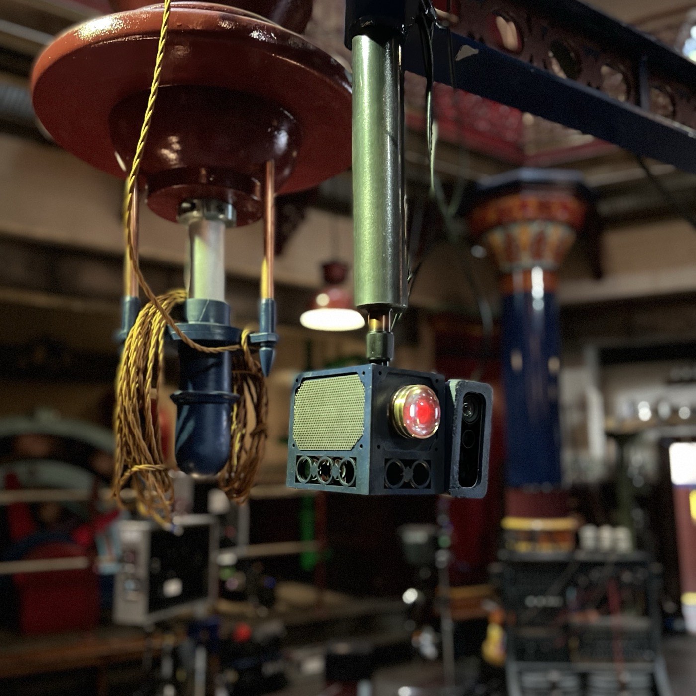 An Azure Kinect clamped to a pole mount among the set's period light fittings, emitter glowing