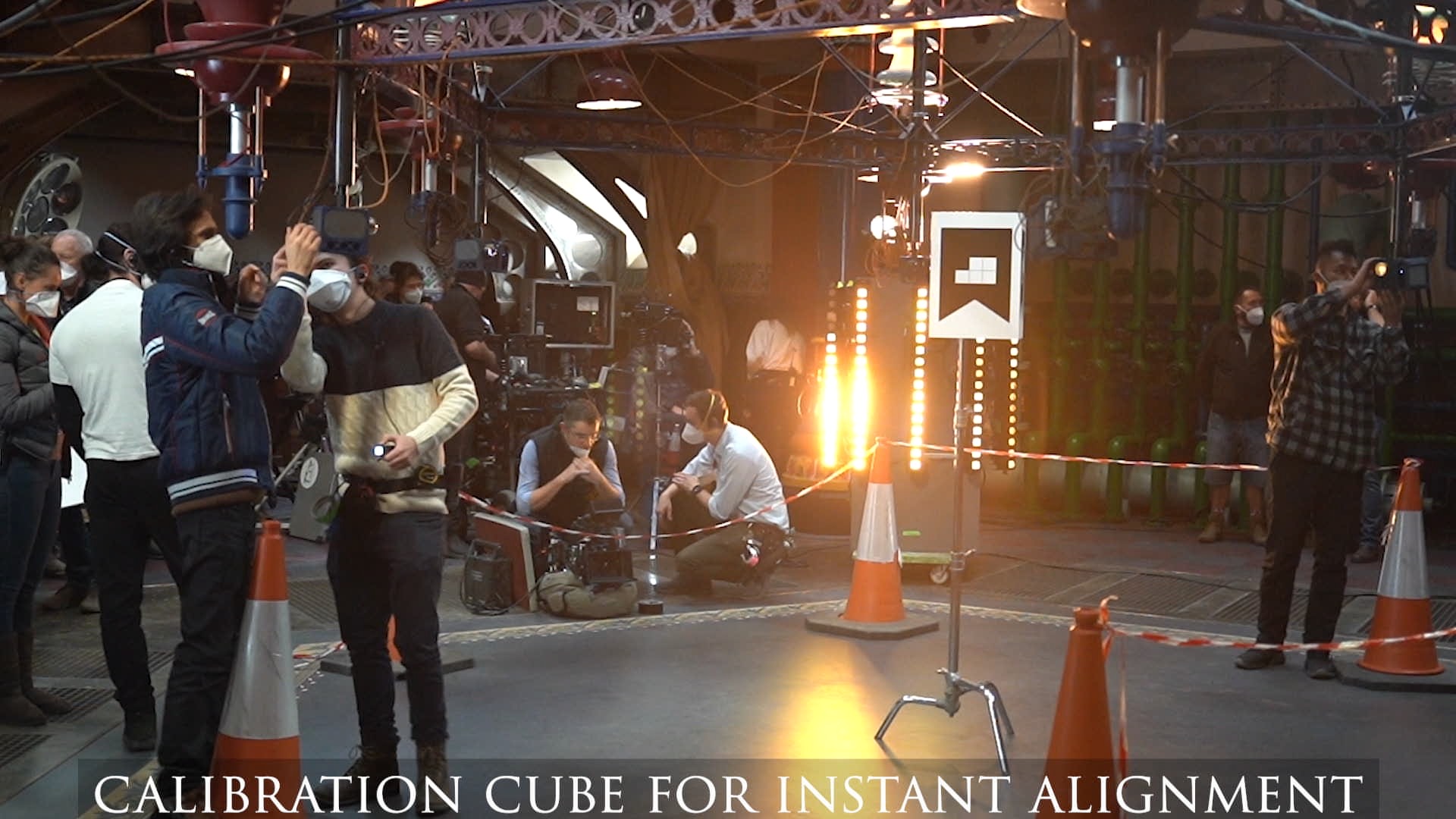 The set mid-work — crew around the capture volume, the calibration cube on its stand, cones marking the edge