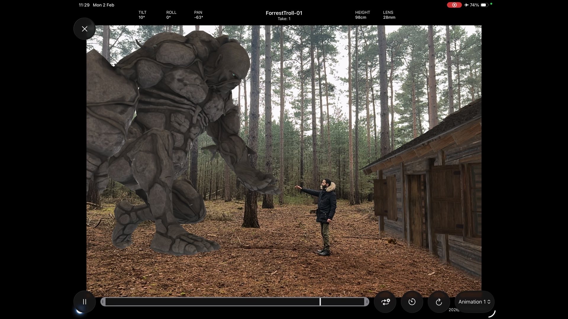 The app on an iPad: a stone troll standing among real trees with a person beside it, arms out — the app's camera readouts across the top and an animation timeline along the bottom