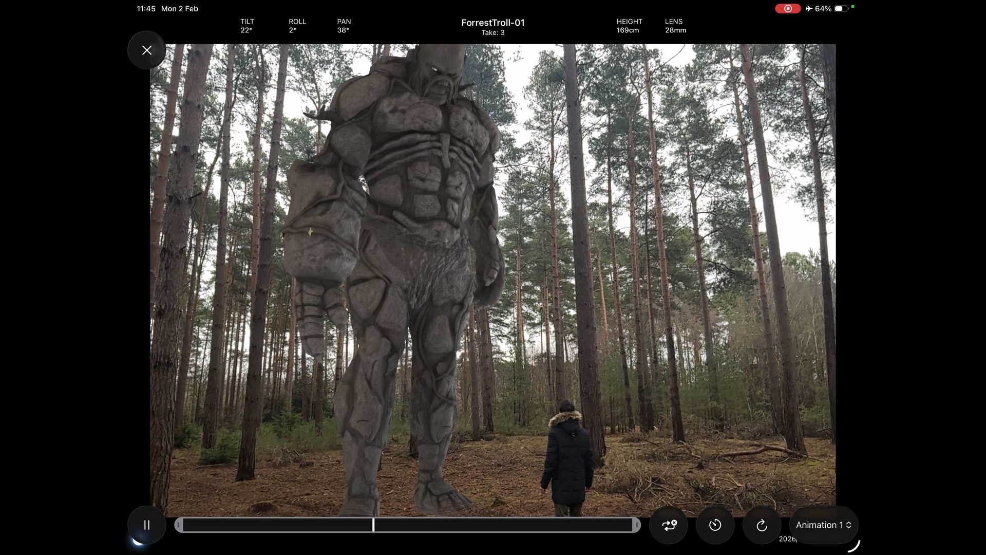 Looking up at the stone troll among the trees, a figure small beneath it, with the app's camera readouts across the top and the animation timeline along the bottom